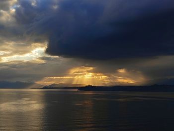 Scenic view of sea against dramatic sky during sunset