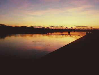 Bridge over river at sunset