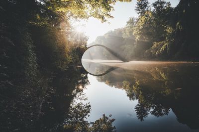 Distant arch bridge over lake in summer