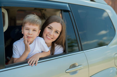 Portrait of smiling boy on car