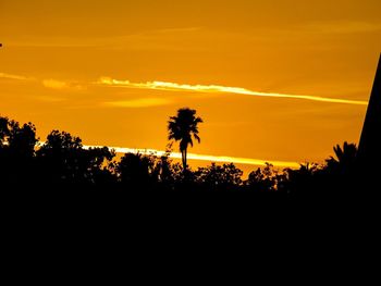 Silhouette palm trees against sky during sunset