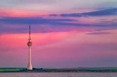 Communications tower against sky during sunset