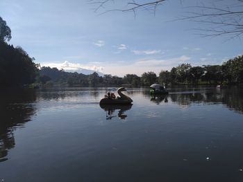 Man sitting in lake against sky