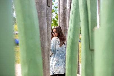 Portrait of woman standing by plants