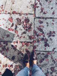 Low section of woman standing on footpath