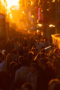 Crowd on street in city at sunset