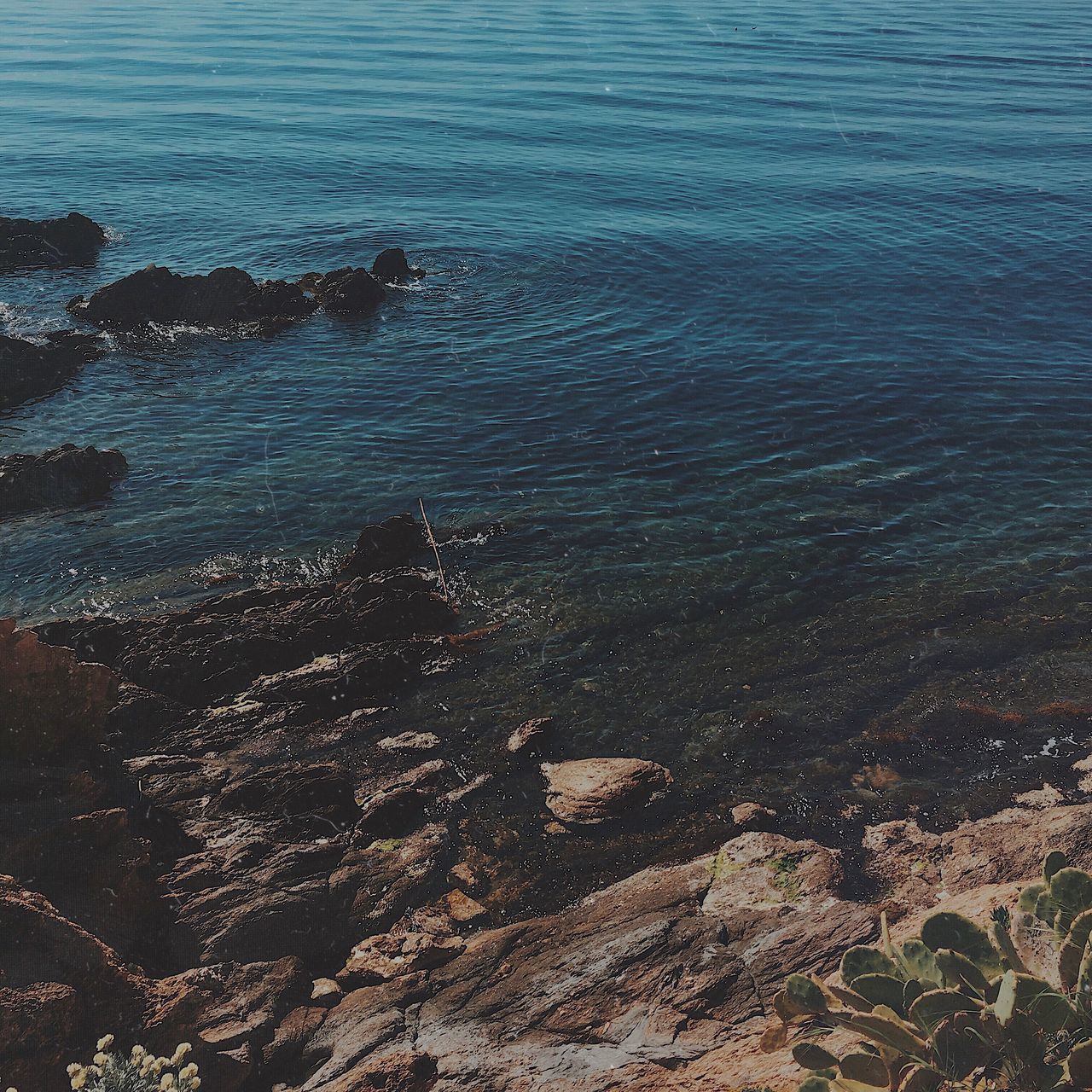 HIGH ANGLE VIEW OF ROCKS AT SEA