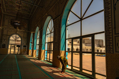 Rear view of woman seen through glass window of building