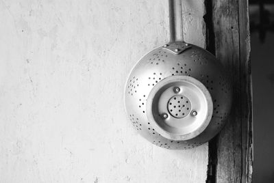 Close-up of colander hanging on wall at home