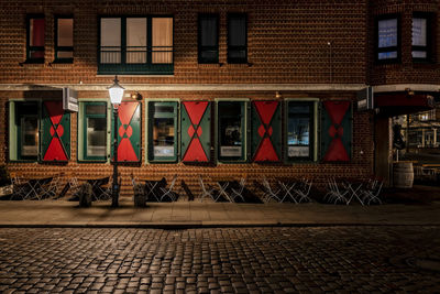 Building by street in city at night