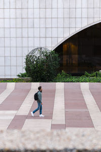 Lonely male student with backpack walking in university campus