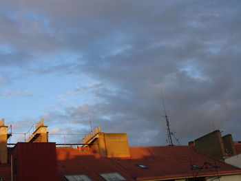 Low angle view of buildings against cloudy sky