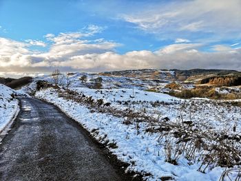 Snow covered road against sky