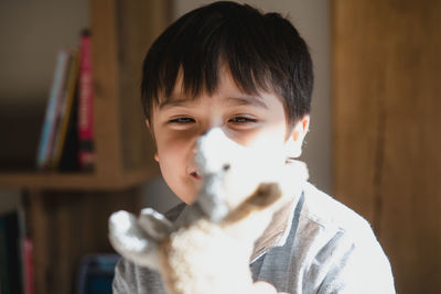 Cute boy holding toy at home