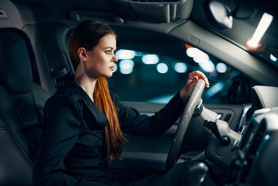 Side view of woman driving car