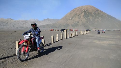 Man riding motorcycle on mountain against sky