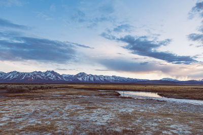 Dramatic dusk sky over arid plains and owens river against sierra nevada mountains