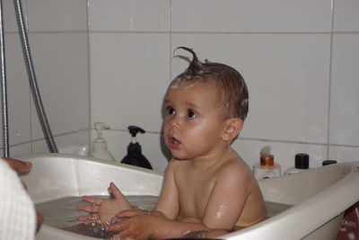 Shirtless baby boy in bathtub