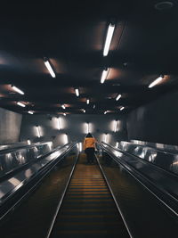 Rear view of woman on escalator