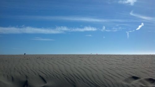 Scenic view of desert against blue sky