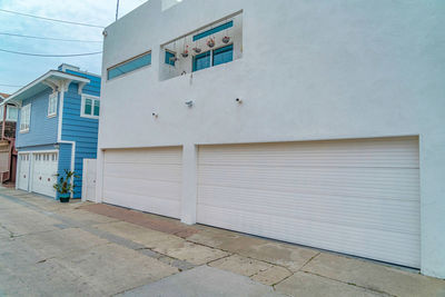 Empty footpath by building against sky