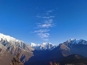 Scenic view of snowcapped mountains against blue sky