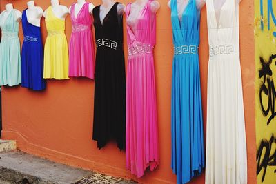 Colorful dresses for sale hanging on wall