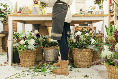 Woman standing by flowers in basket at floral shop