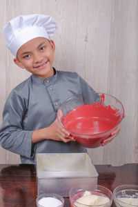 Portrait of boy preparing food on table at home