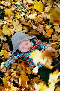 Low angle view of girl with leaves during autumn