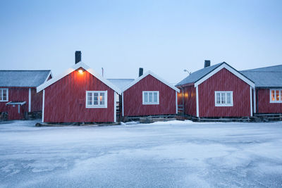 Houses by building against clear sky during winter