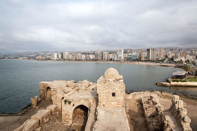 Bridge over sea against buildings in city