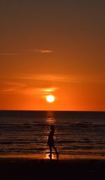 Silhouette of man on beach at sunset