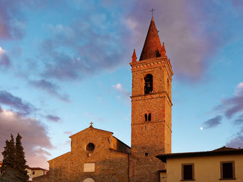 Low angle view of bell tower amidst buildings against sky