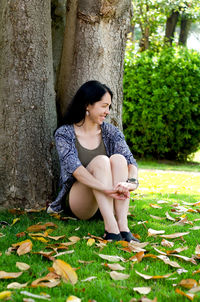 Portrait of young happy brunette asian woman relaxing in city, park. summer vacation. travel