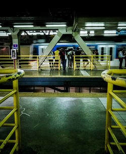 People standing at illuminated railroad station