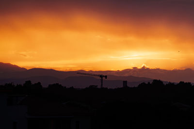 Silhouette buildings against sky during sunset