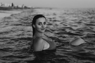 Portrait of young woman swimming in sea