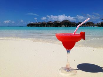 Close-up of red wine on beach