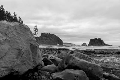 Rocky beach with islands and rock formations in black and white, no people.