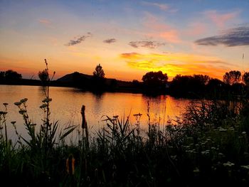 Scenic view of lake against orange sky