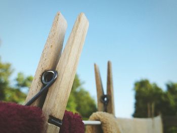 Low angle view of clothespins against blue sky