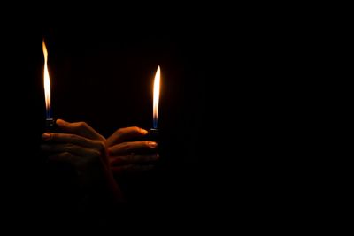 Close-up of lit candle in dark room