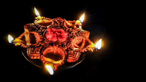 Close-up of lit candles against black background