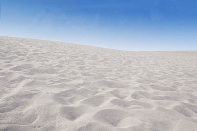 Scenic view of desert against clear blue sky