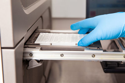 Scientist loading samples to a rt-pcr thermal cycler at the laboratory. 