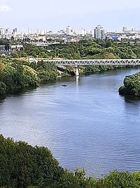 Scenic view of river by buildings against sky