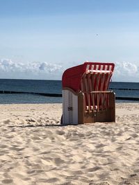 Chair on beach against sky