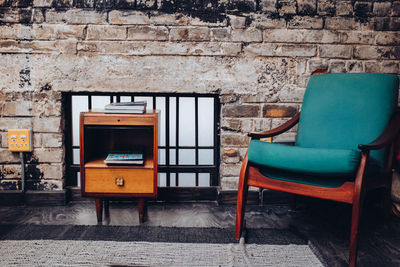 Empty chairs and table against wall