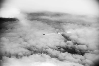 Cars on road against cloudy sky